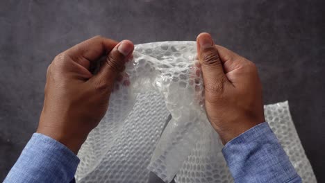 manos con envoltura de burbujas