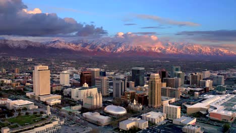 Luftaufnahme-Der-Skyline-Von-Salt-Lake-City,-Sonnenuntergangsansicht,-Leuchtende-Skyline-Von-Salt-Lake-City,-4K-Drohnenaufnahme-Mit-Dem-Wasatch-Mountain-Im-Hintergrund