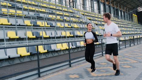 Happy-Sportive-Couple-Running-Together-In-The-Stadium