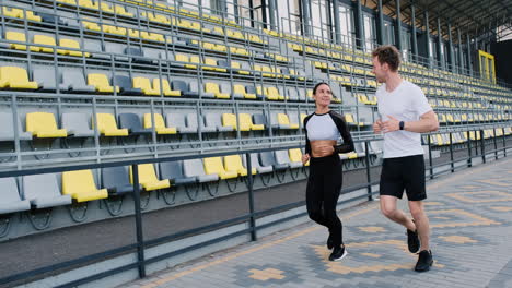 Feliz-Pareja-Deportiva-Corriendo-Juntos-En-El-Estadio