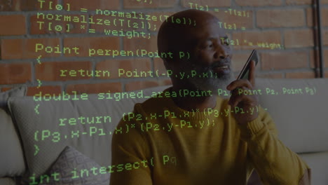 data processing over african american senior man talking on smartphone sitting on the couch at home