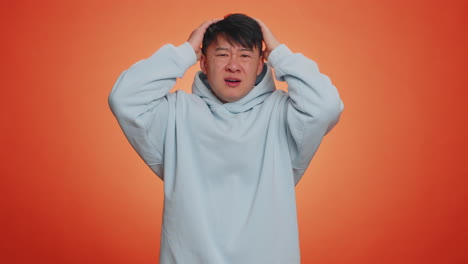 Handsome asian man loses becoming surprised by lottery results bad fortune loss unlucky news