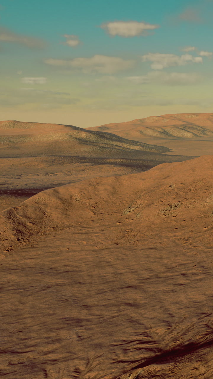 Wide view of a dry landscape with hills and a valley at sunset