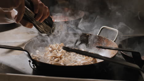 mushrooms being sautéed in a hot pan