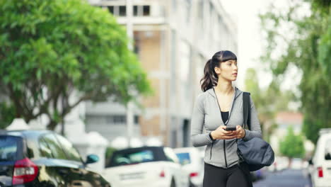 woman walking and using phone in city street