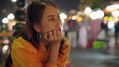 Lonely-young-Asian-women-in-yellow-outfit-sitting-and-thinking-with-blur-background