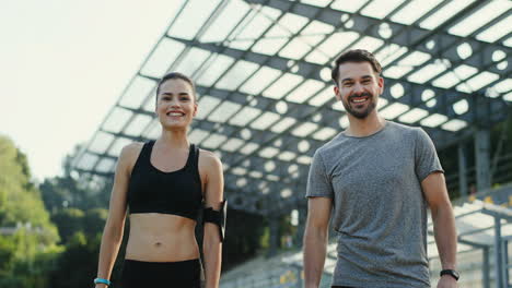 una pareja de joggers jóvenes dándose cinco y sonriendo a la cámara después de correr el tiempo de entrenamiento 1