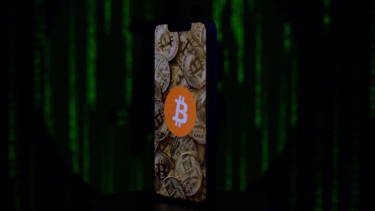 bitcoin en un iphone con código verde en el fondo