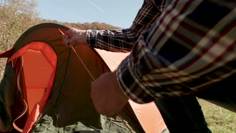 Close-up-view-of-man-checking-the-camping-tent