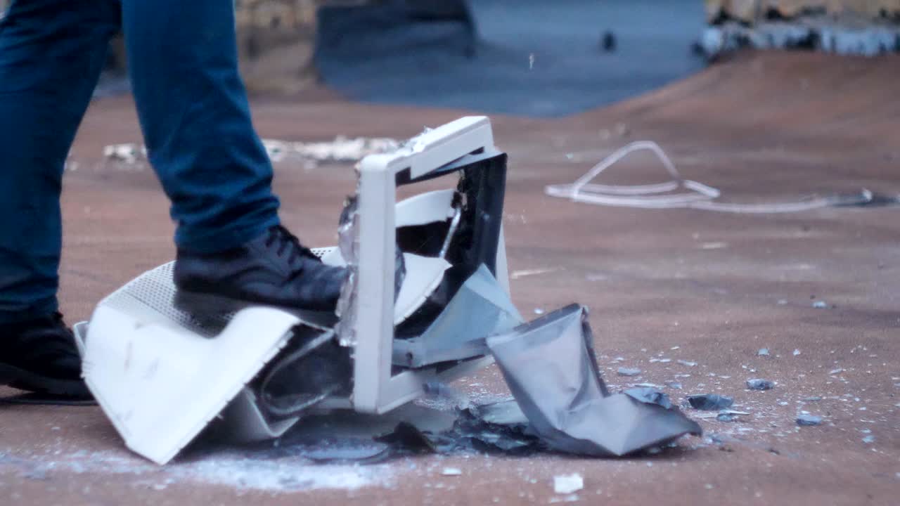 los pies masculinos en los zapatos destruyen el viejo monitor de vidrio. 60 fps