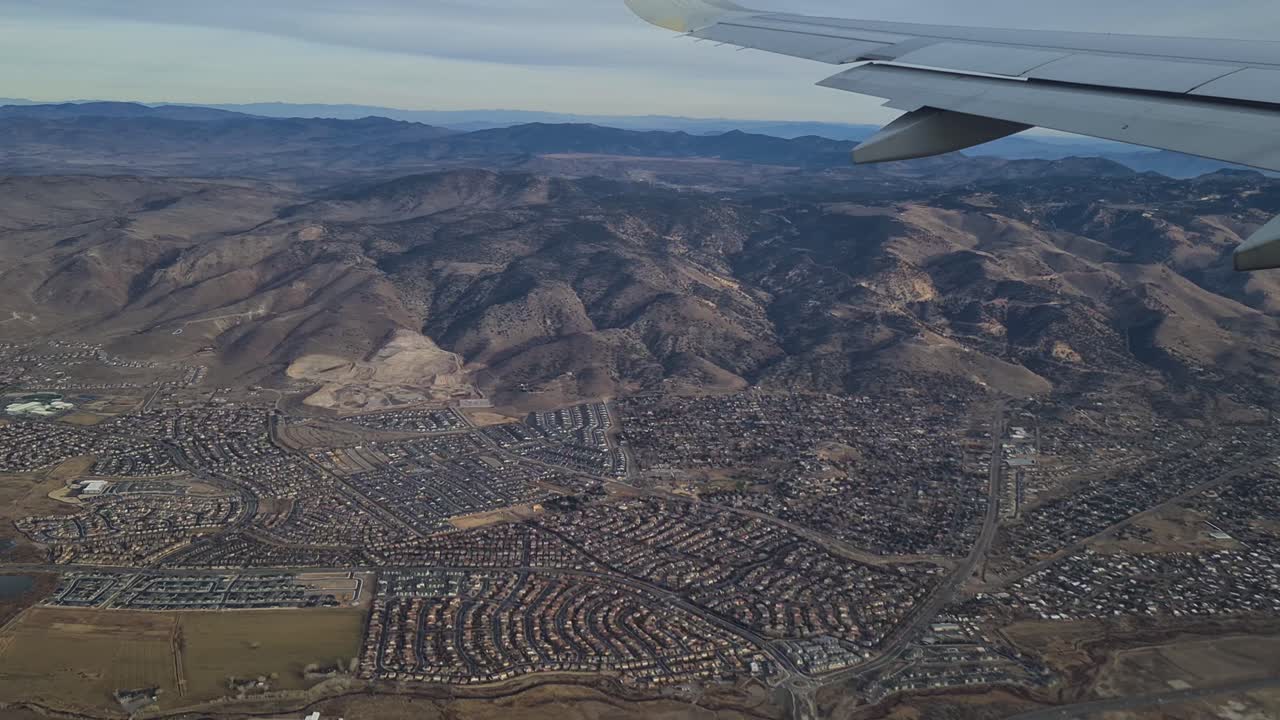 volando sobre los suburbios residenciales de reno, nevada, estados unidos, el pasajero del avión pov sobre el ala