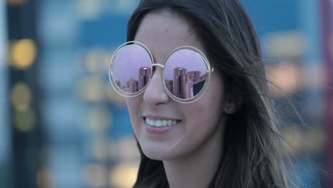 girl wearing big round sunglasses outdoors in the evening smiling happy