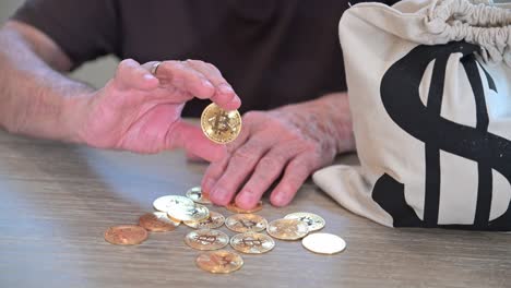 old retiree holds a token bitcoin souvenir in his hand seated by a bag of cash