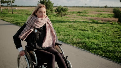 mujer en silla de ruedas disfrutando de un paseo por el parque