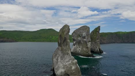 aerial seaside panorama. circle flight around huge rocks towering in teal bay