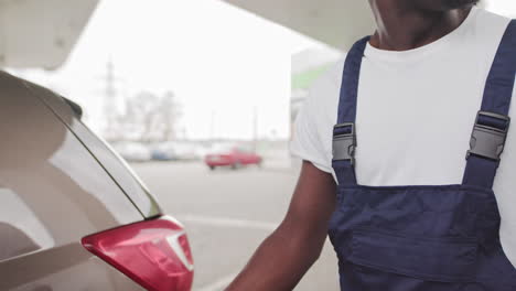 man refueling a car at a gas station
