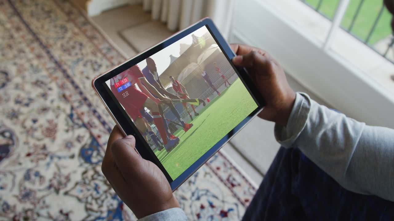 태블릿에서 하키 경기를 보고 집에 앉아 있는 남자의 복합 사진