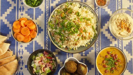 putting cooked couscous with chicken on table top view. arabian cuisine. pita, hummus, falafel and vegetable salad. traditional middle eastern culture. delicious rice with meat. homemade food concept