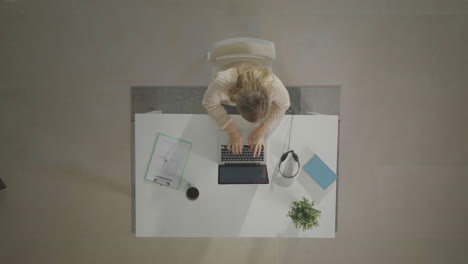 mujer sentada y trabajando en una computadora portátil