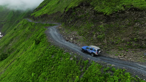 Vista-Aérea-De-Un-Todoterreno-Conduciendo-Por-El-Peligroso-Camino-De-La-Muerte-A-Través-Del-Paso-Abano-En-Tusheti,-Georgia