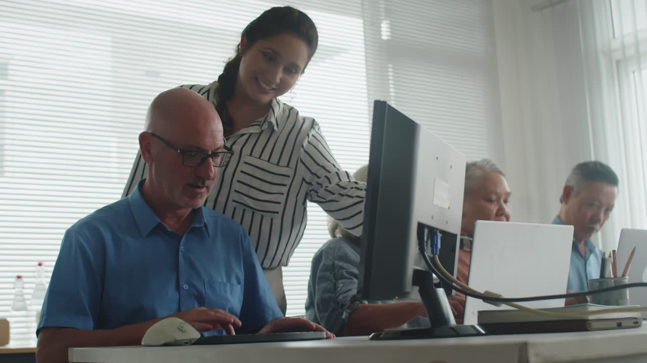 Female Teacher Giving Computer Knowledge to Male Pensioner