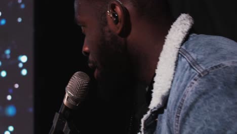 man singing into a microphone on stage