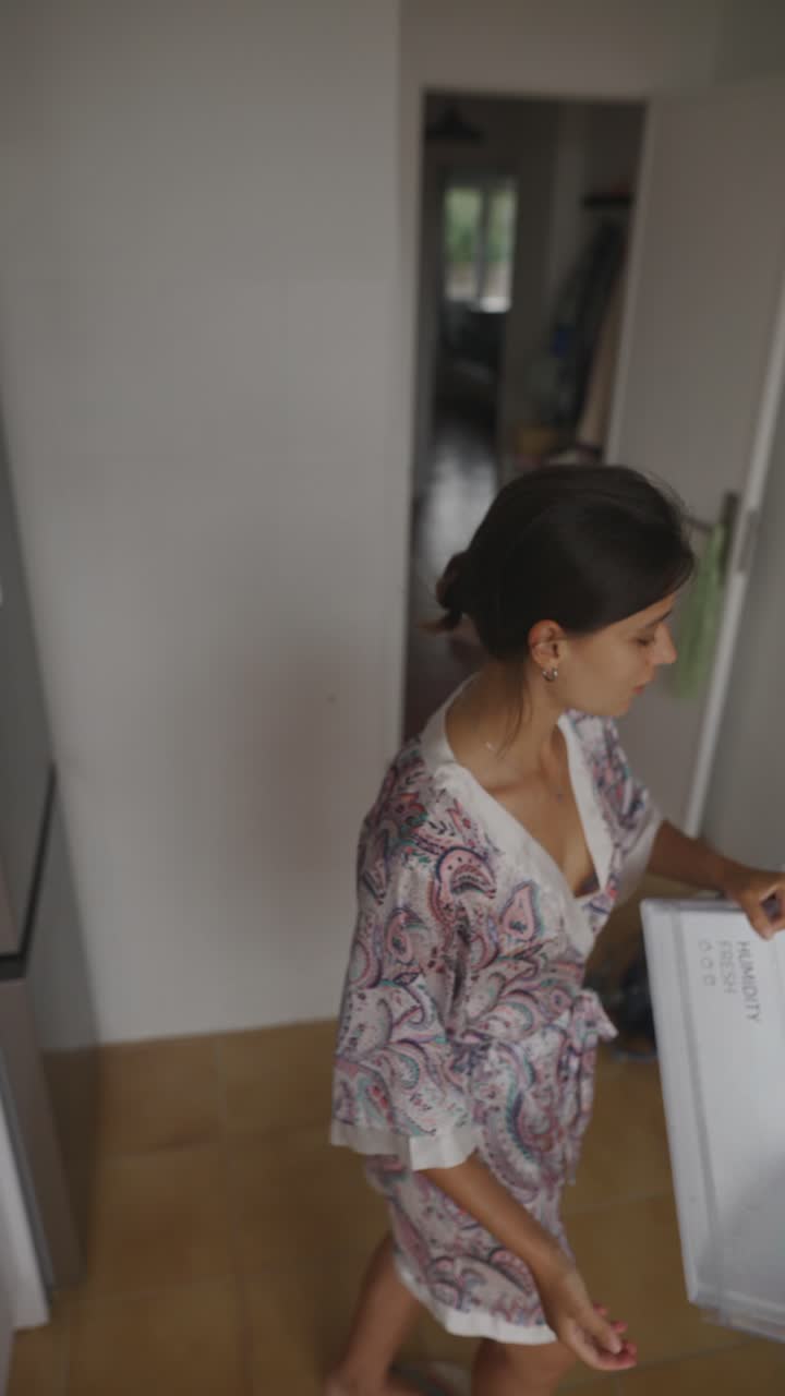 Woman in Kitchen Opening Refrigerator