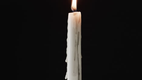 Video-of-white-candle-with-white-flame-and-copy-space-on-black-background