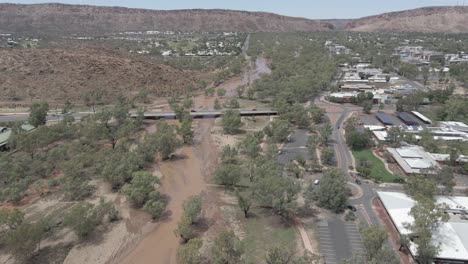 aerial view of todd river with vehicles crossing on the bridge. ephemeral river in northern territory, australia. sideways shot