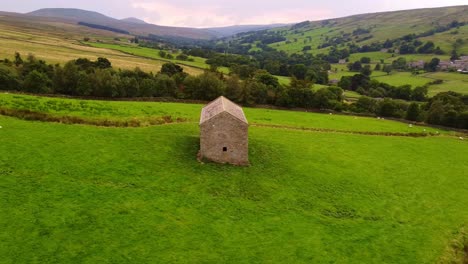 Toma-Aérea-De-Seguimiento-Horizontal-Lento-De-Un-Granero-Aislado-En-El-Valle-De-Yorkshire-Dales