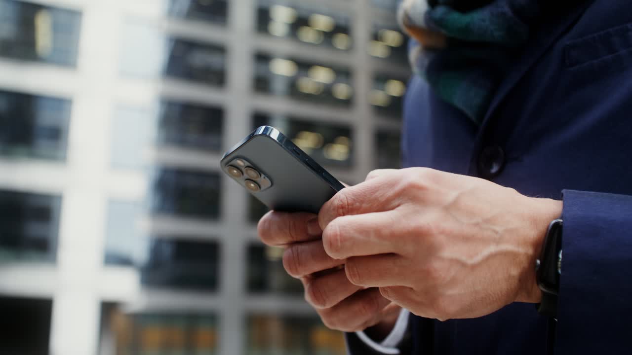 Uomo d'affari che usa lo smartphone in città