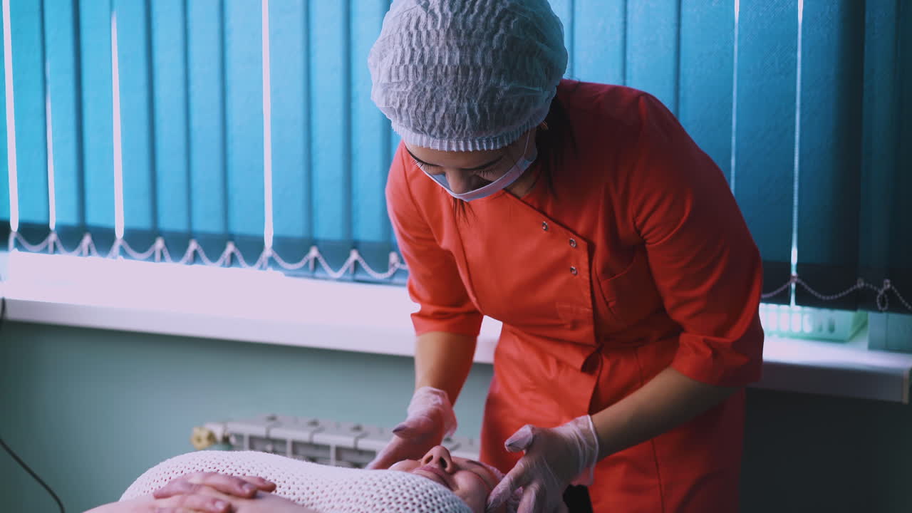 esteticista con gorra hace masaje de la cara de una mujer de tamaño grande