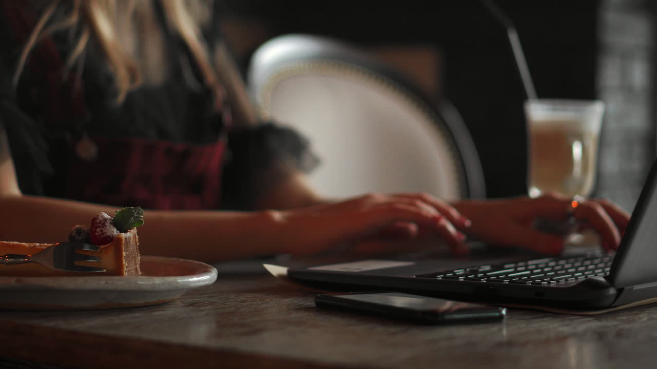 woman holding phone and pointing on empty screen on background of laptop notebook passport wallet on craft table, top view office home
