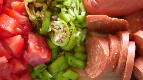 sliced tomatoes, green peppers and red sausage