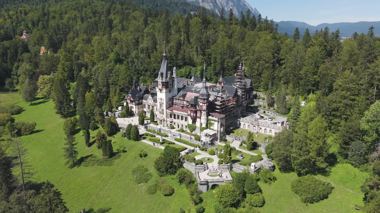 Aerial view of Peleș Castle set in a lush forest, highlighting its location within the Carpathian landscape