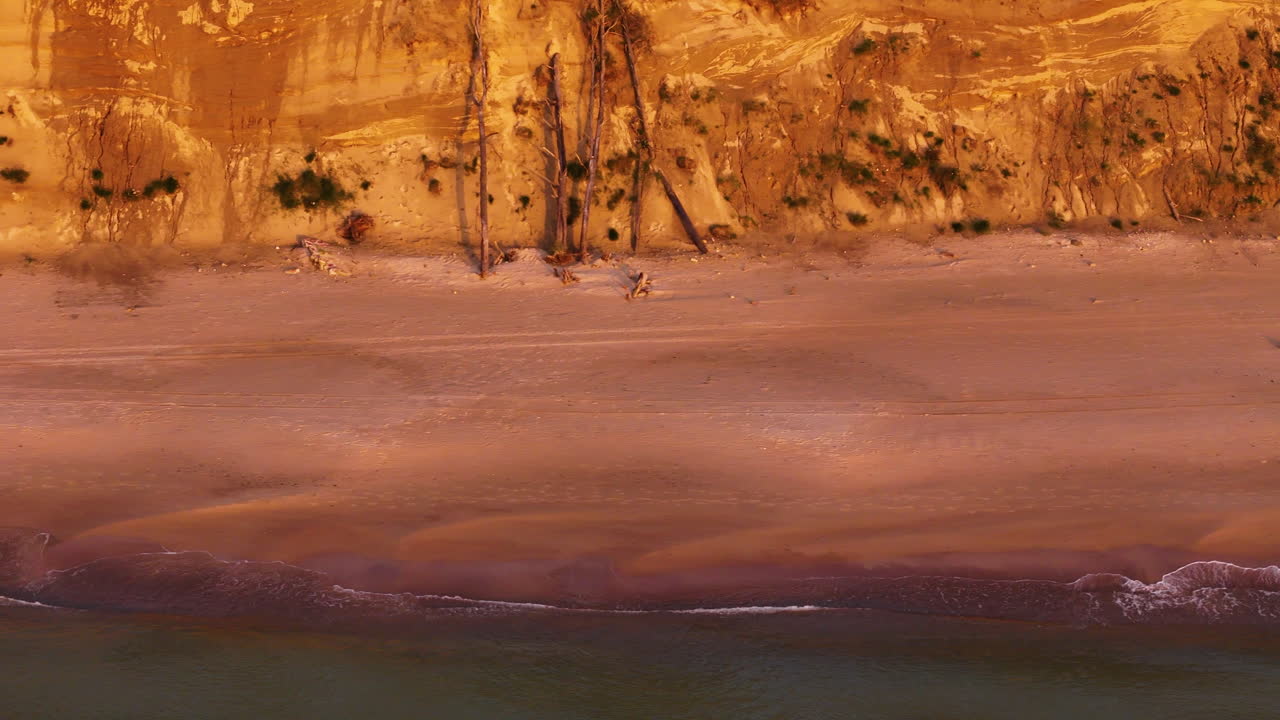 Sandy Baltic sea coast and dunes during sunset, aerial view