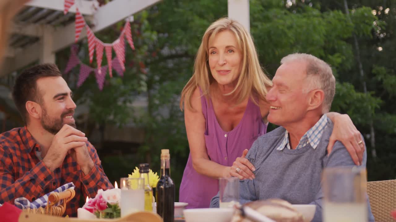 밖에서 점심을 먹으면서 시니어 남자와 키스하는 시니어 여성