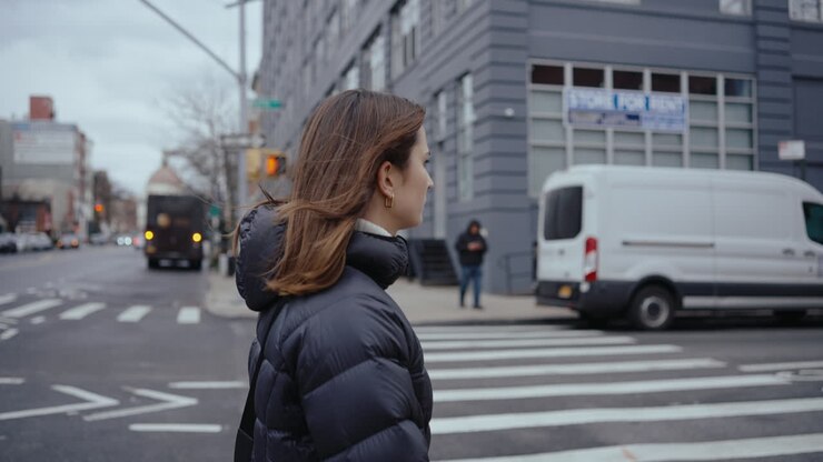 都市の通りを歩く女性