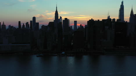 aerial tilt down towards the legendary midtown manhattan skyline at dramatic dusk