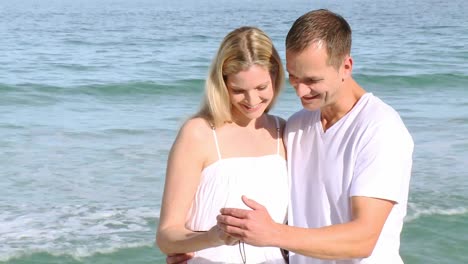 close up of couple on the beach watching photos