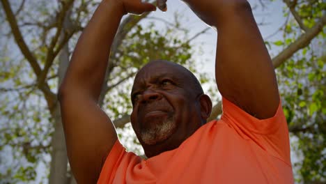 vista de bajo ángulo de un hombre anciano afroamericano activo realizando yoga en el jardín del asilo de ancianos 4