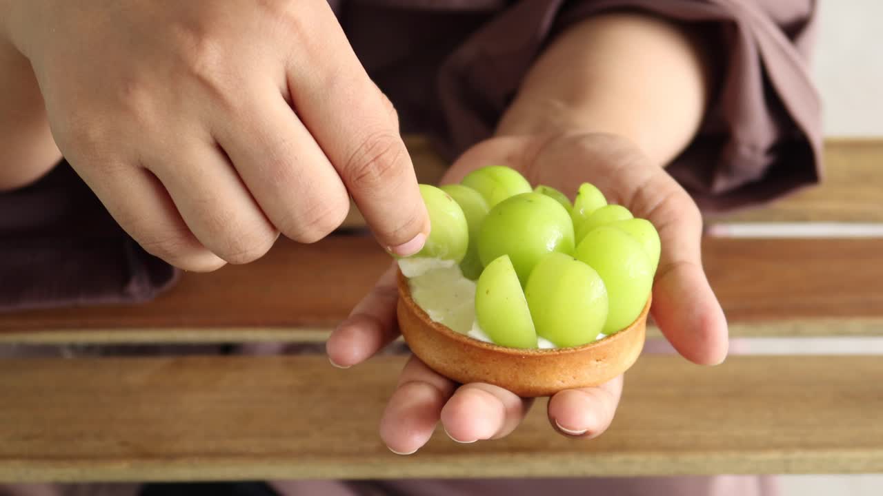 mujer decorando una deliciosa tarta de uva