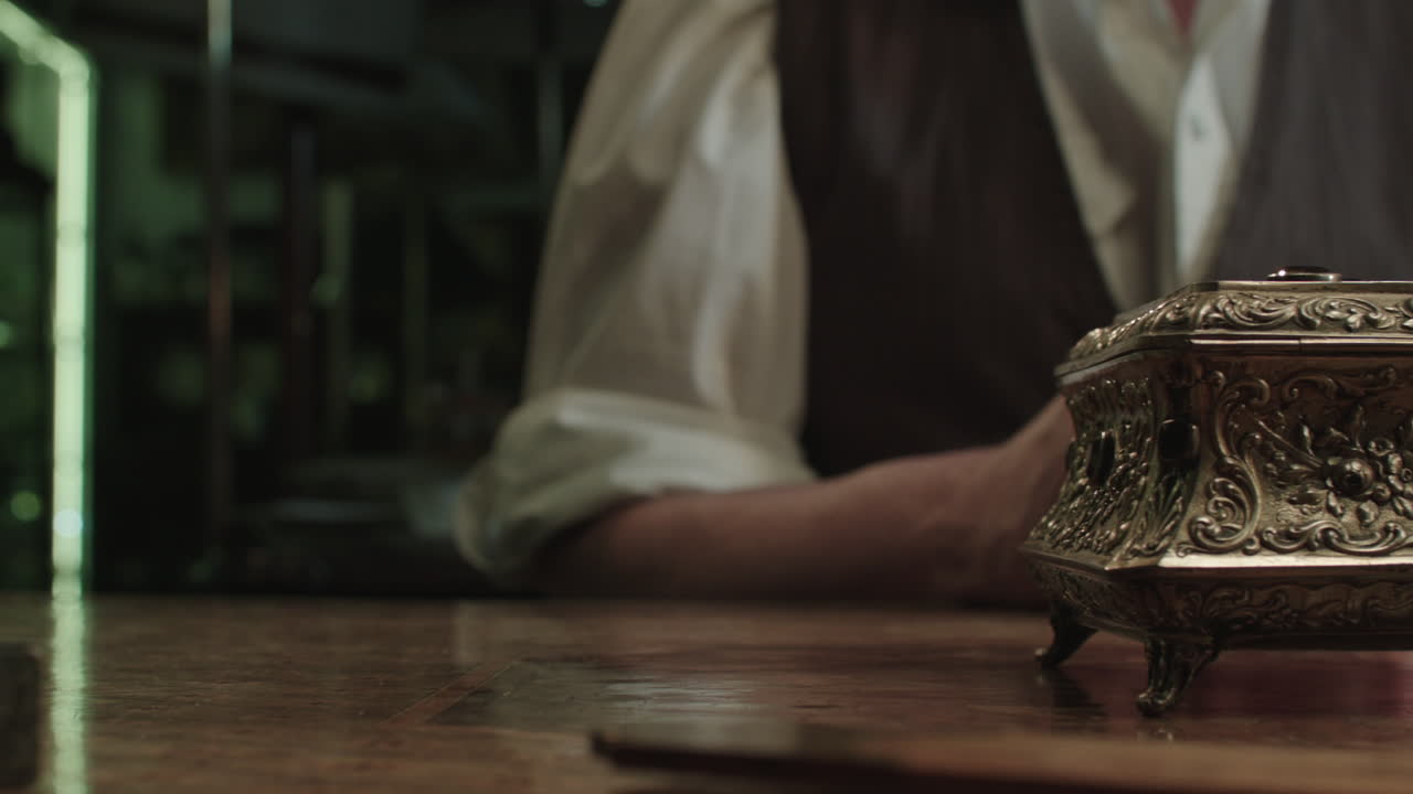 An older man opens antique gold box