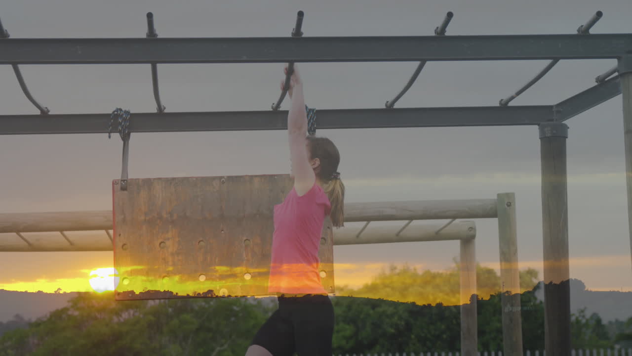animación de la puesta de sol sobre la mujer caucásica en el curso de obstáculos colgado.