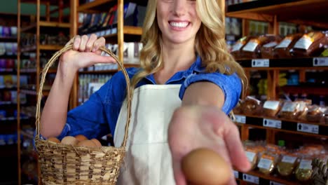 smiling female staff holding basket and egg in super market