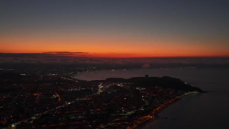 Aerial view of coastal Penha municipality and Balneario Picarras illuminated by sunset with glowing horizon, Santa Catarina, Brazil