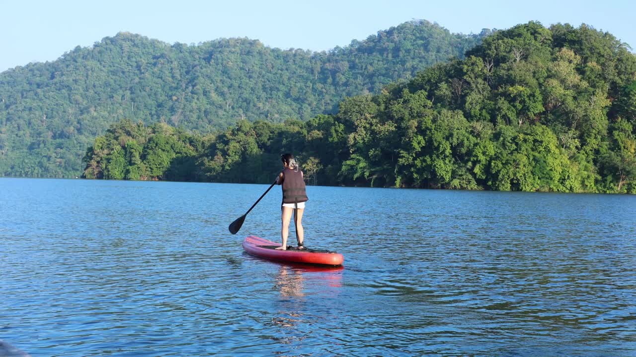 человек, катающийся на веслах на спокойном озере с деревьями