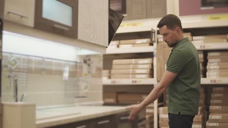 man shopping for kitchen cabinets in a home improvement store