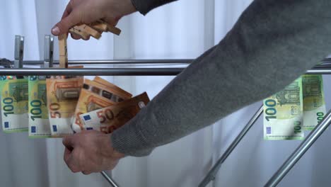 money hanging to dry with clothespin - euro money banknotes after  washing machine - illegal cash 50, 100 €  and mafia money laundering - increase in the cost of living, energy and gas