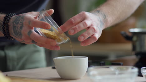 chef grinding sesame seeds with mortar and pestle